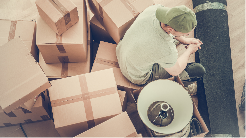 Guy seated on top of move out boxes